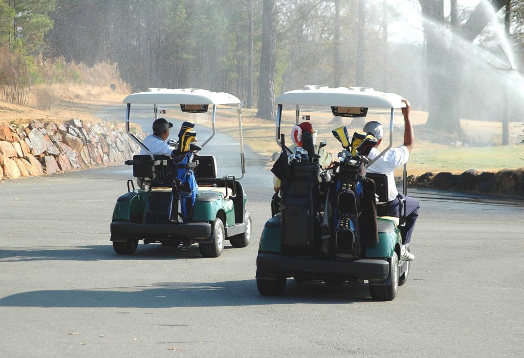 A couple of golf carts driving down a road