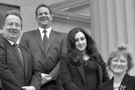 A group of people in suits and ties are posing for a picture.