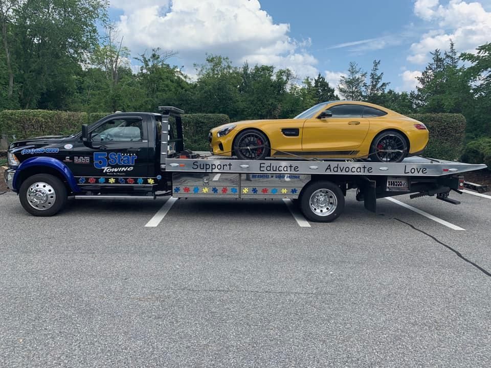 A yellow sports car is being towed by a tow truck.