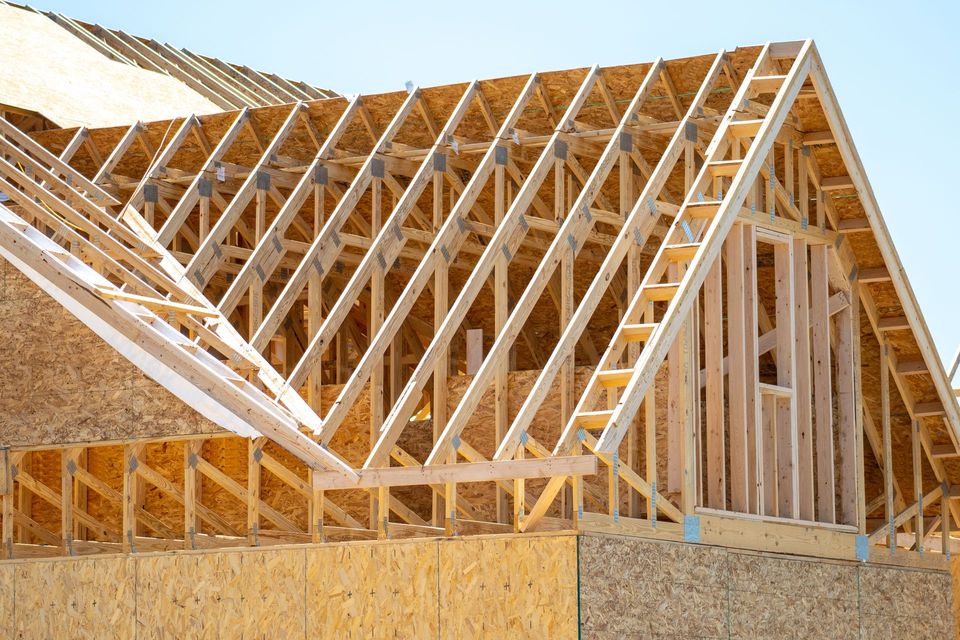 The roof of a house is being built with wooden beams.