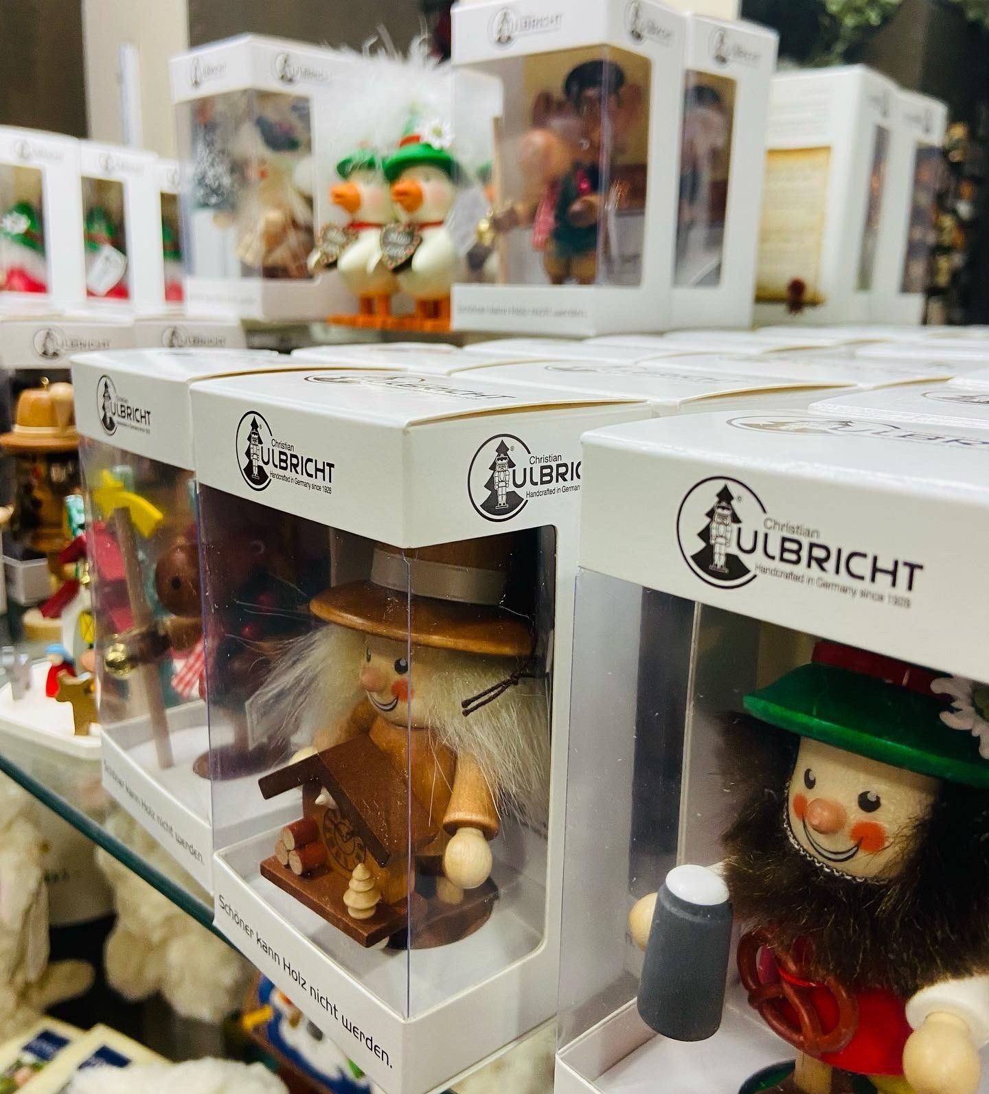 Rows of Lubricht nutcracker figurines in white display boxes, including a green-hatted one in front.