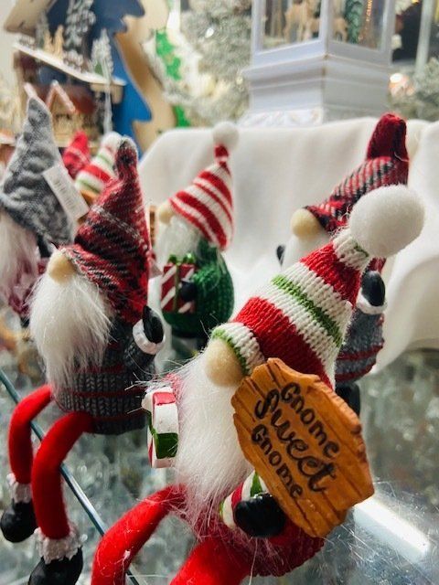 Small plush gnome ornaments with red-and-white hats and fuzzy beards, one holding a wooden “handmade” tag.