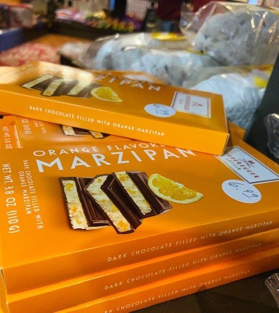 Orange marzipan dessert bars in bright orange boxes on a display table
