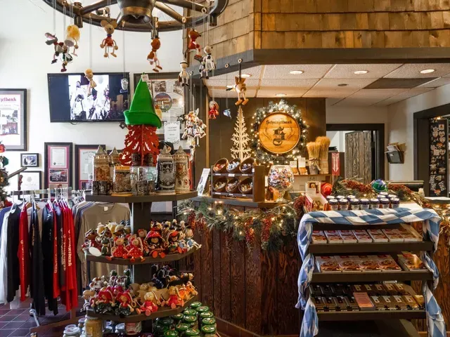 Festive gift shop with holiday decorations, clothing racks, ornaments, and displays throughout the room