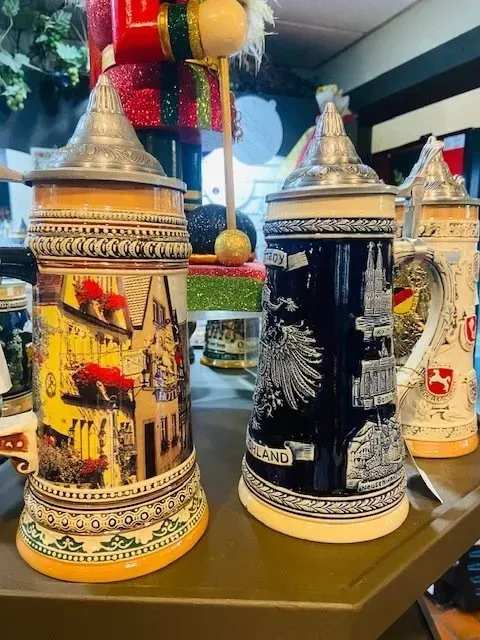 Decorative painted metal containers with pointed lids displayed on a shelf in a shop