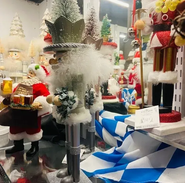 Christmas store display with Santa figurines, fluffy white decorations, and a blue-and-white checkered ribbon