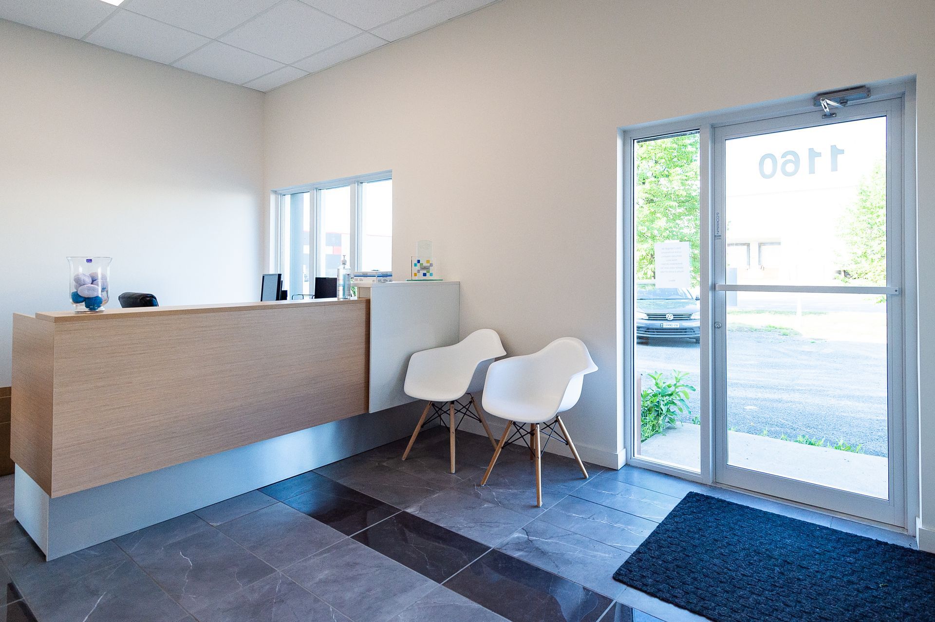 Une salle d'attente avec un bureau, des chaises et une porte.