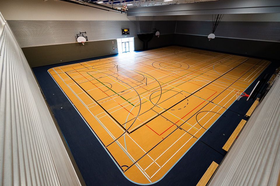 Un terrain de basket-ball intérieur avec la lettre e dessus