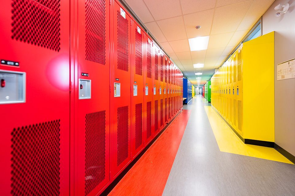 Une rangée de casiers rouges et jaunes dans le couloir d'une école.