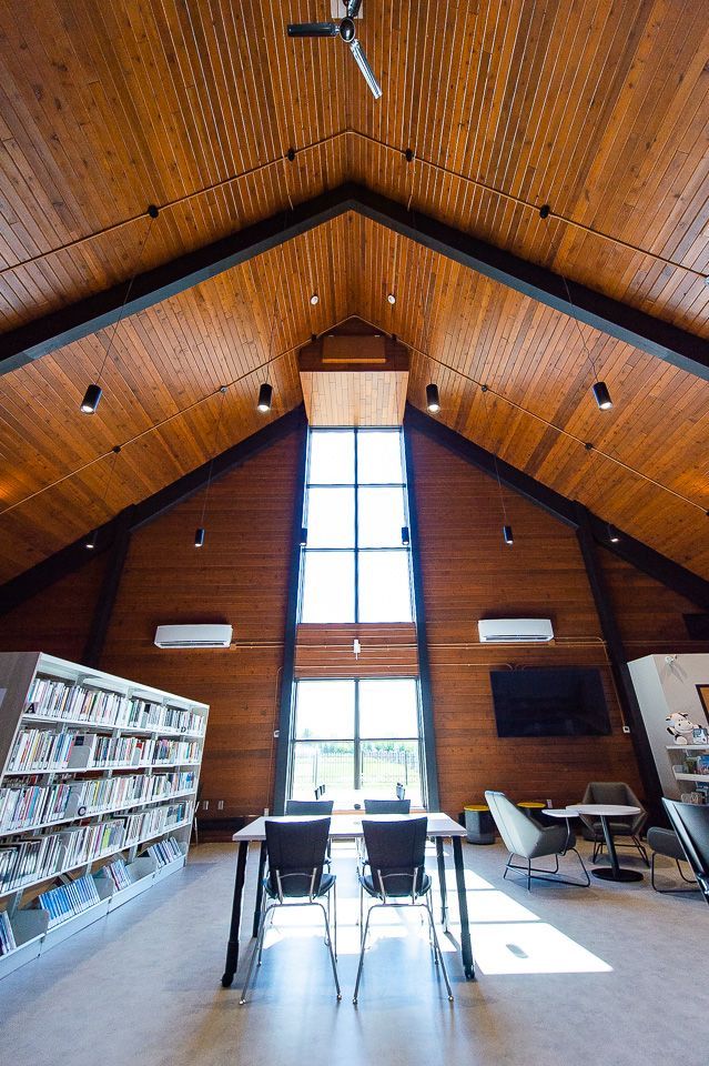 Une bibliothèque avec un plafond voûté et une grande fenêtre.