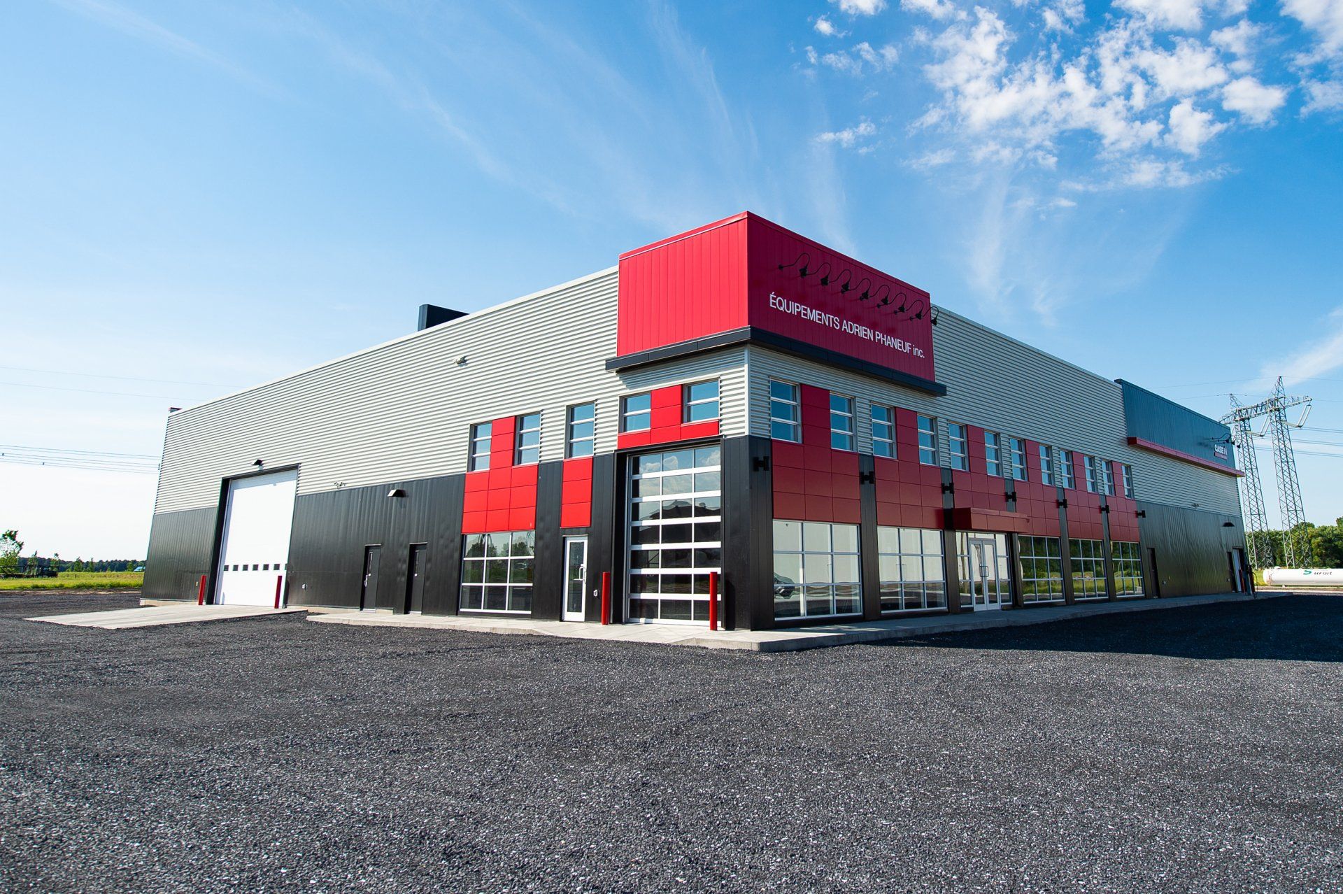 Un grand bâtiment avec beaucoup de fenêtres est situé au sommet d'un terrain en gravier.