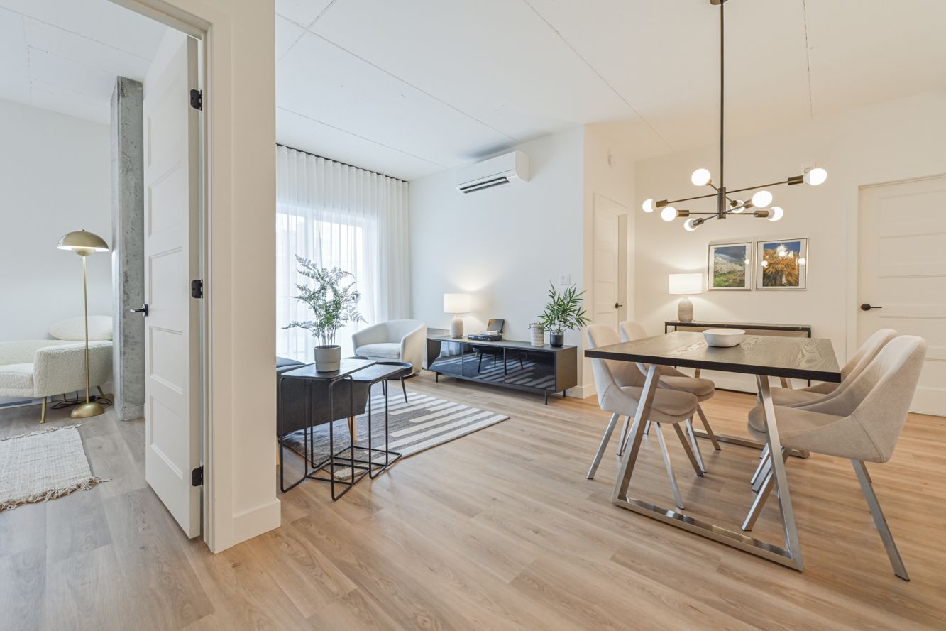 Des gratte-ciel aux façades de verre s'élancent vers un ciel bleu où brille le soleil.