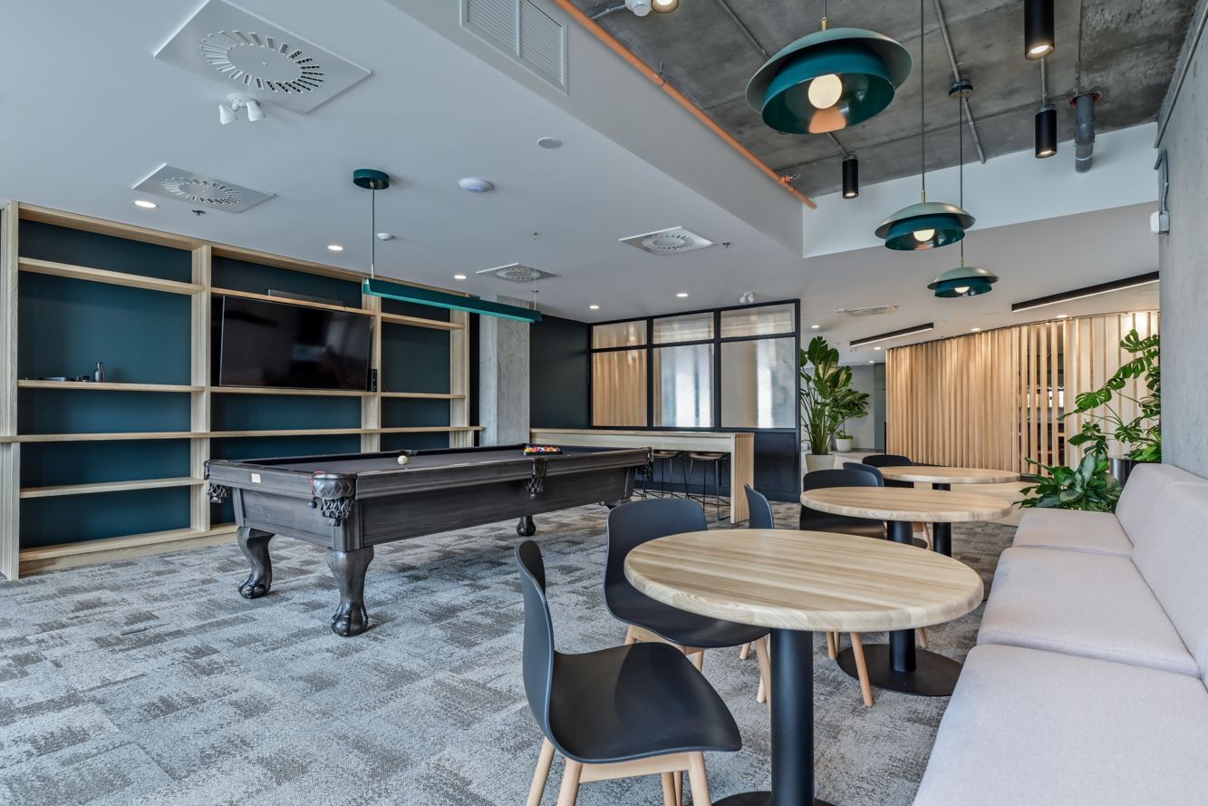 Des gratte-ciel aux façades de verre s'élancent vers un ciel bleu où brille le soleil.