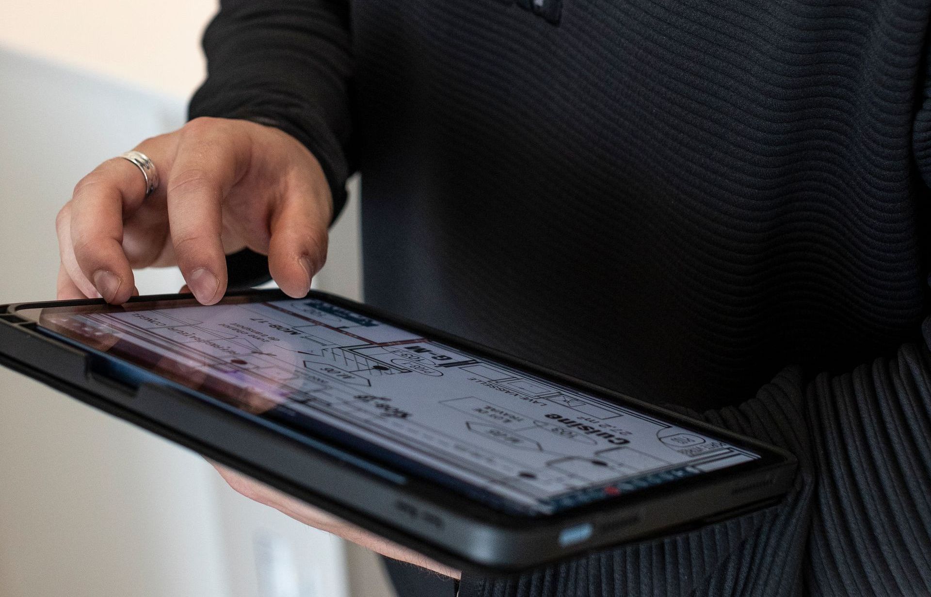 Une personne tient une tablette dans ses mains et l'utilise.