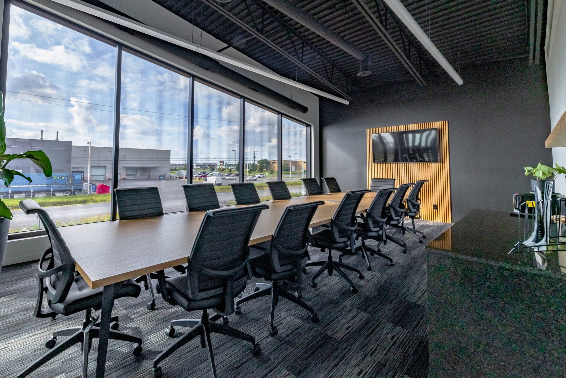 Une salle de conférence avec une longue table et des chaises.