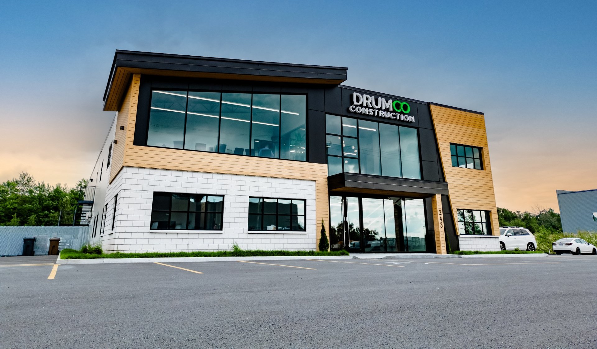 Un grand bâtiment avec beaucoup de fenêtres et une voiture garée devant.