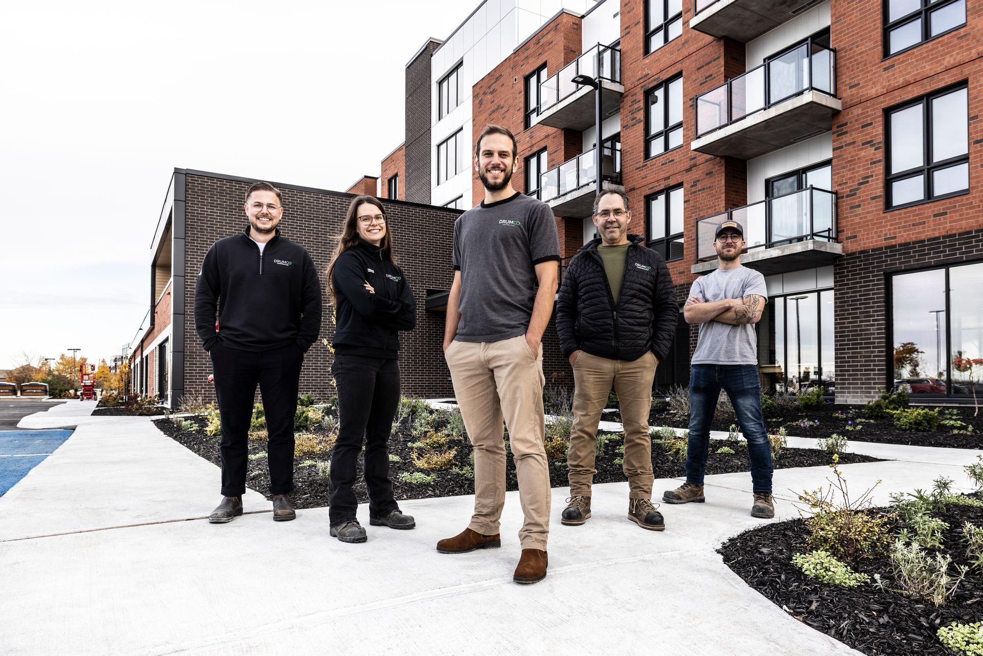 Un groupe de personnes se tient devant un bâtiment en briques.