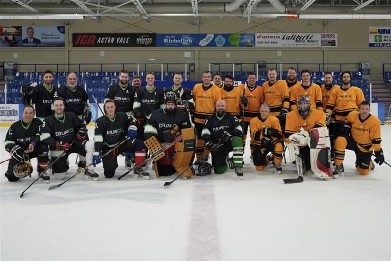Un groupe de joueurs de hockey pose pour une photo sur la glace