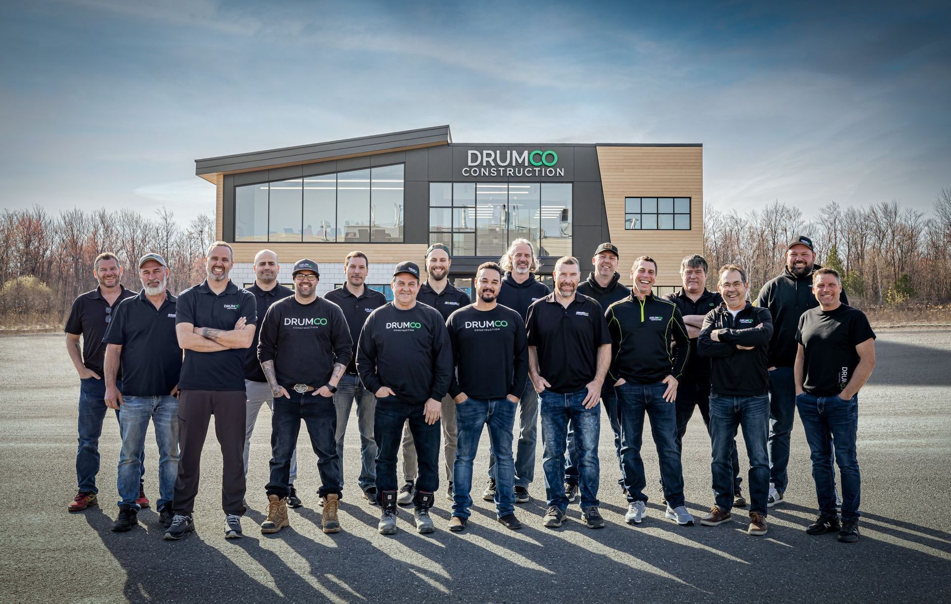 Un groupe d'hommes pose pour une photo devant un bâtiment.
