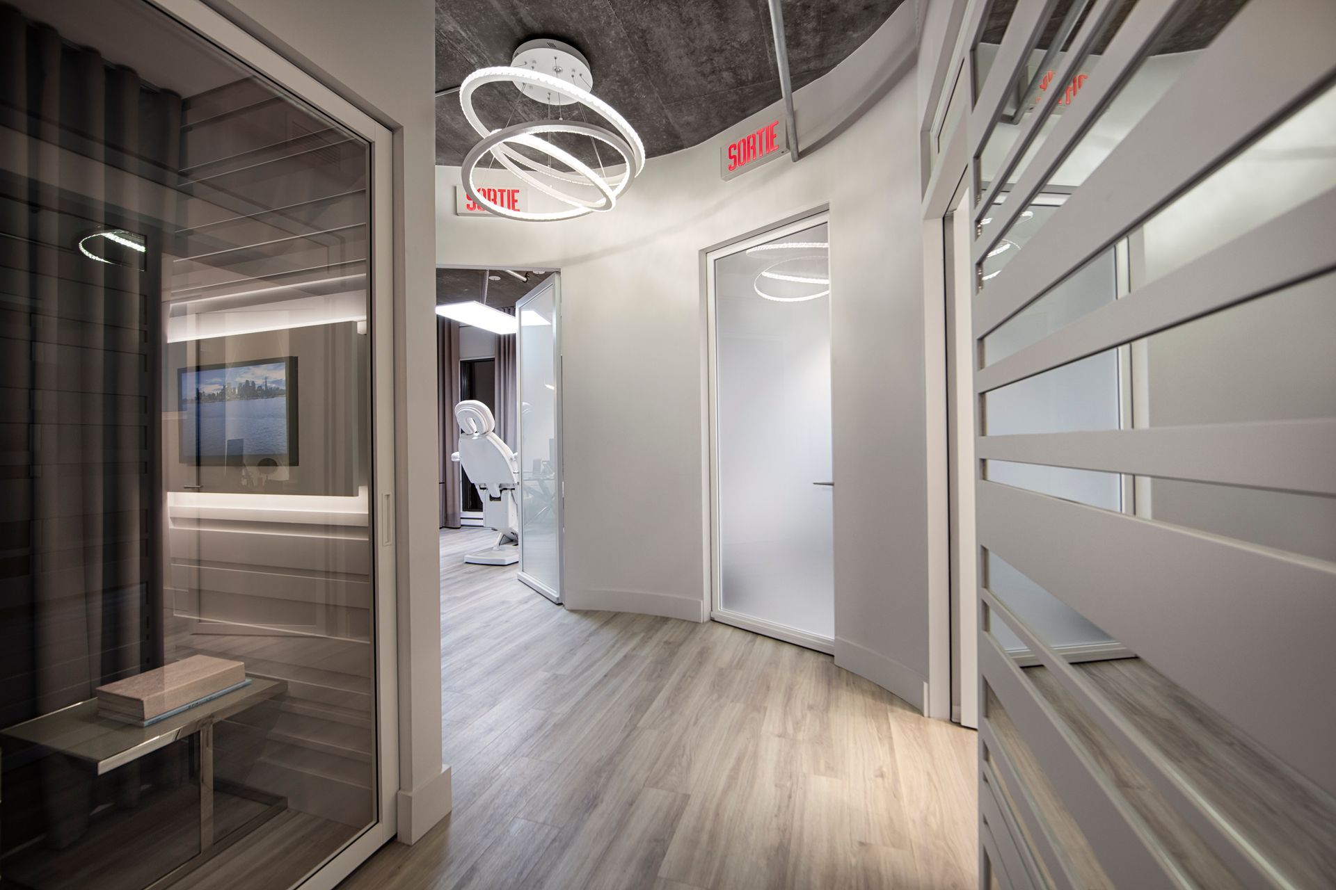 Une femme rousse travaille sur un ordinateur portable, en consultant un plan. Une tasse de café et des papiers sont posés sur la table.