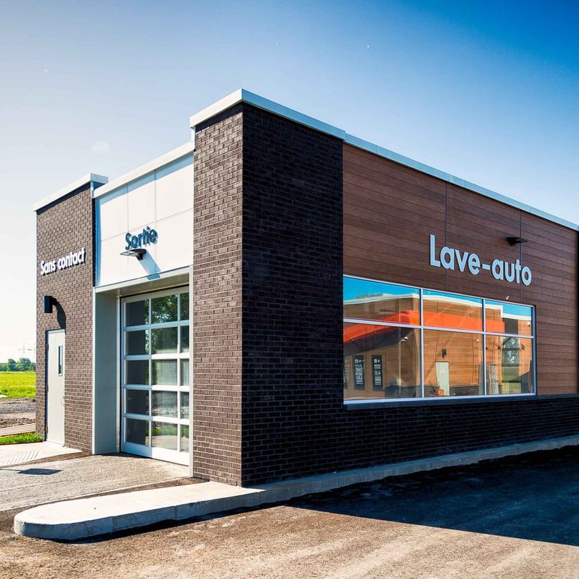 Un grand bâtiment en brique sur lequel est écrit lave-auto