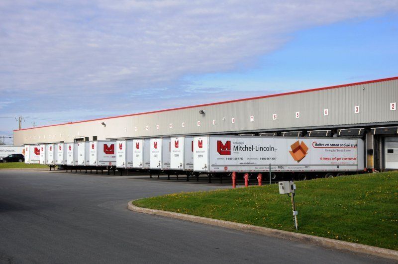 Un grand bâtiment avec beaucoup de camions garés devant lui