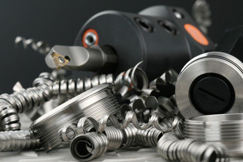 A pile of metal shavings with a machine in the background