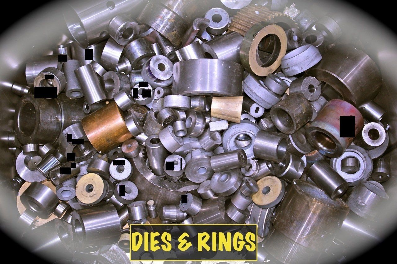 A pile of dies and rings with a yellow sign that says dies & rings