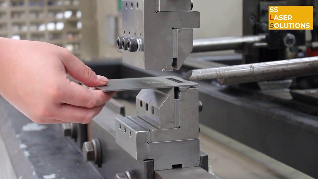 A person is using a machine to cut a piece of metal.