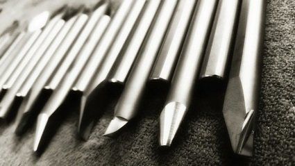 A black and white photo of a row of metal pencils