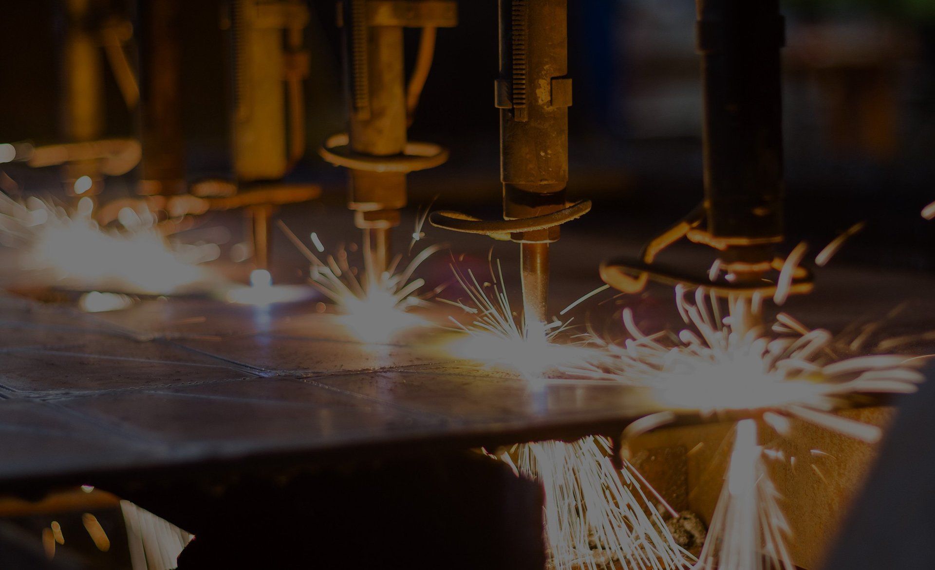 A machine is cutting a piece of metal with sparks coming out of it.