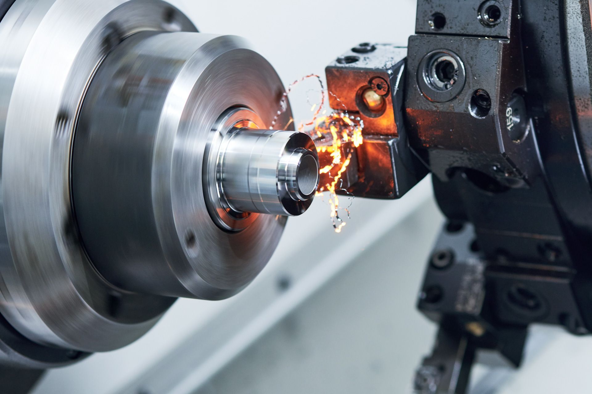 A machine is cutting a piece of metal on a lathe.