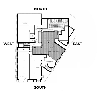 Architectural floor plan of a building, labeled with compass directions. Features include rooms, stairs, and a courtyard.