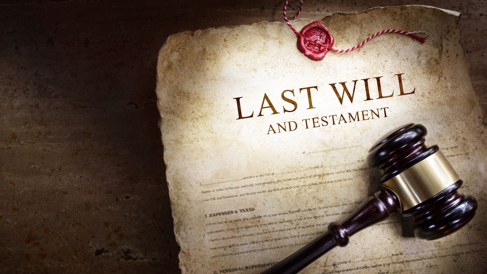 A wooden gavel is sitting on top of a last will and testament.