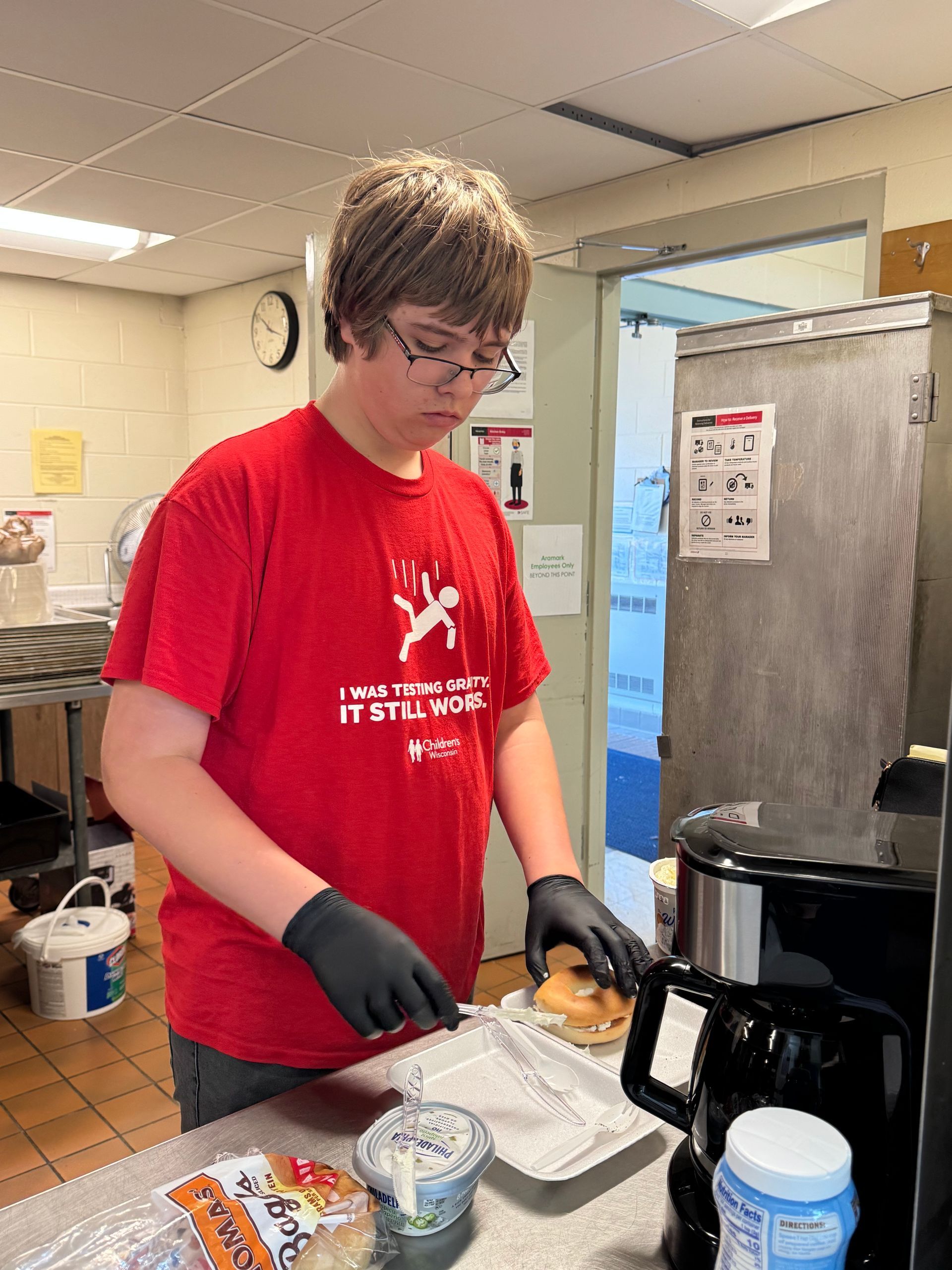 A young man wearing a red shirt that says myth it makes it