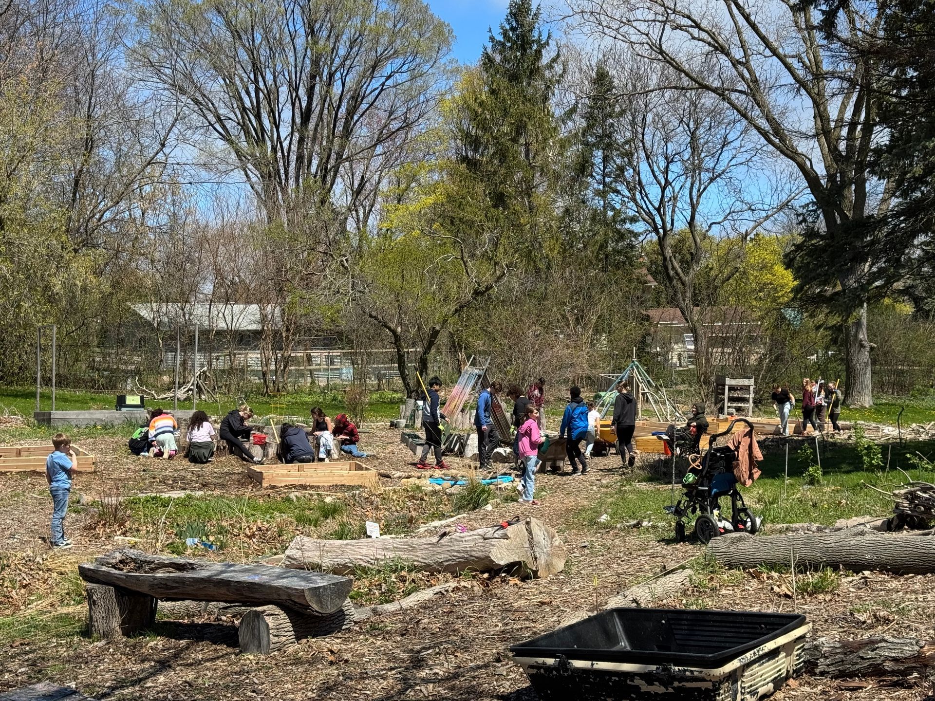 A group of people are sitting on benches in a park.