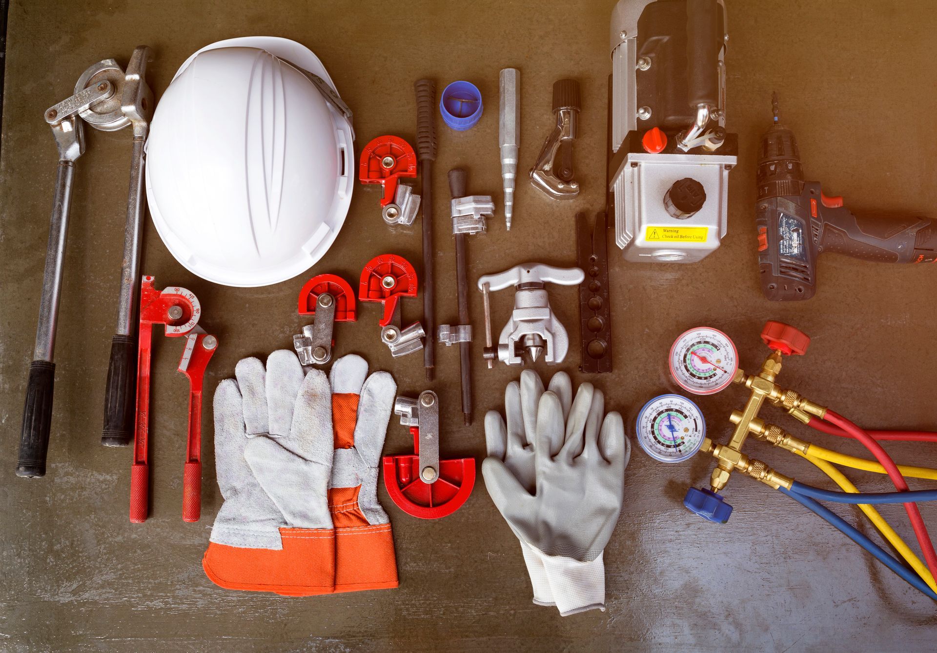 A table topped with a variety of tools including a hard hat and gloves.