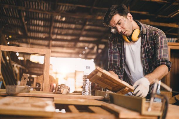 Carpenter inspecting wood planks in a workshop