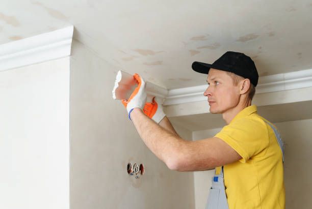 Professional carpenter installing crown molding trim