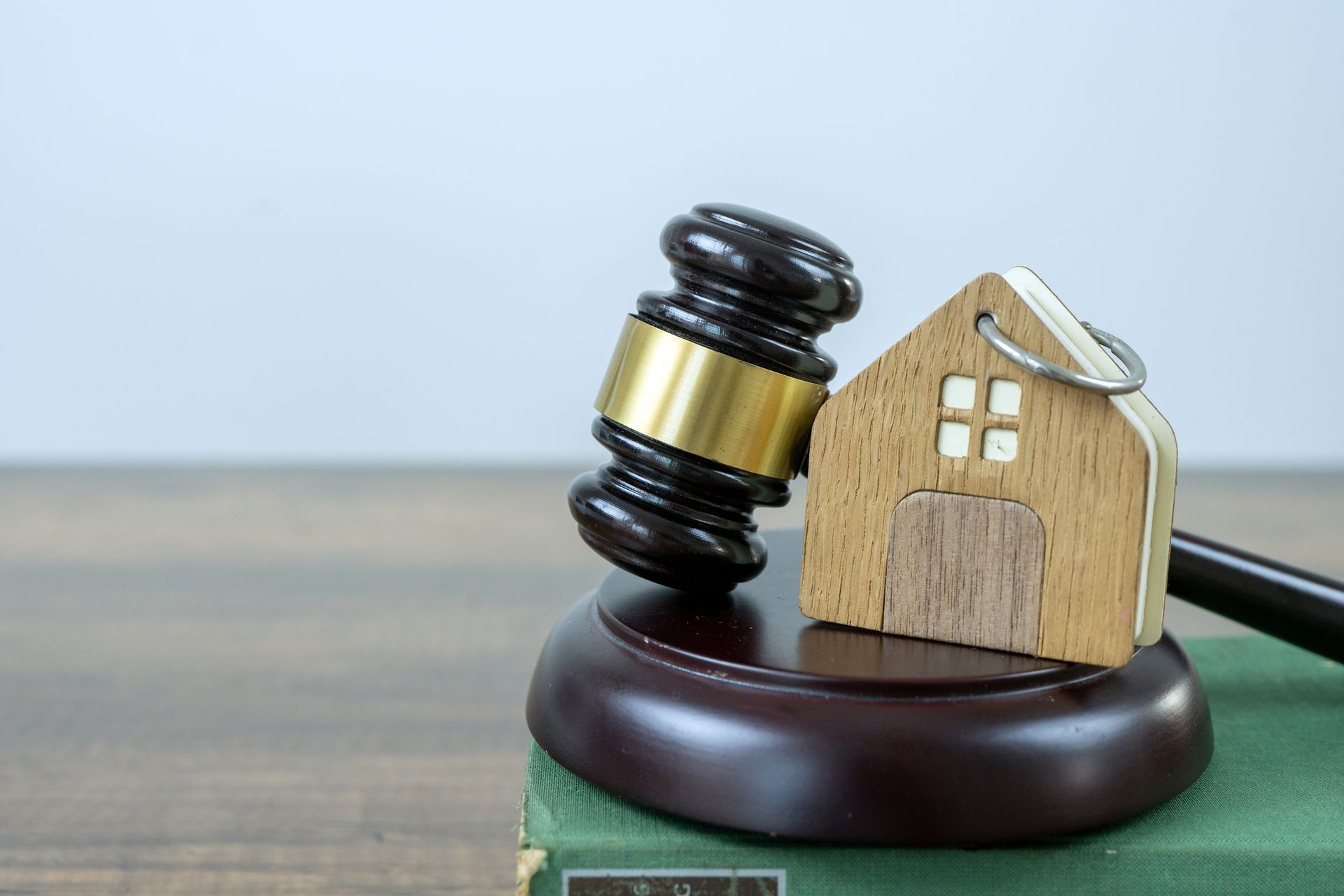 A Wooden Gavel with a House Key on Top of It — Alexander Law Firm in ST Pickens