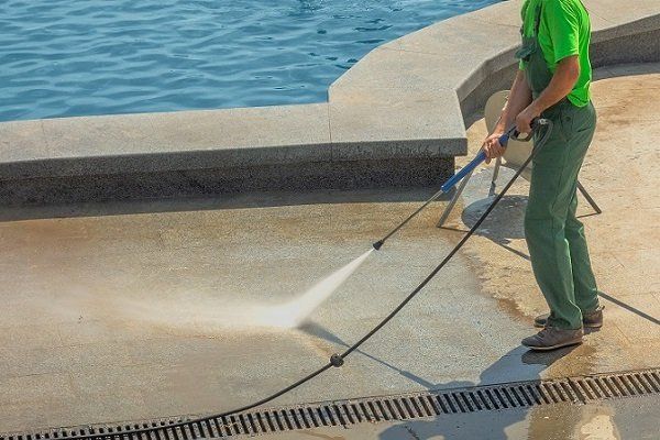 Professional cleaner is pressure washing the swimming pool area in a residential home. Photo taken in Ballarat, VIC.