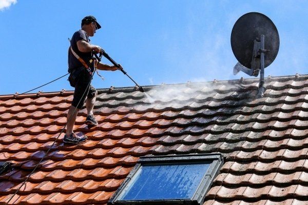 Tile roof of a residential home is being cleaned by a professional pressure washer in Ballarat, VIC.