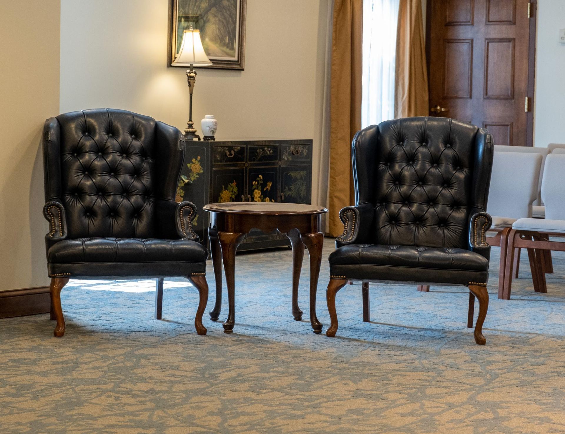 There are two chairs and a table in the room.