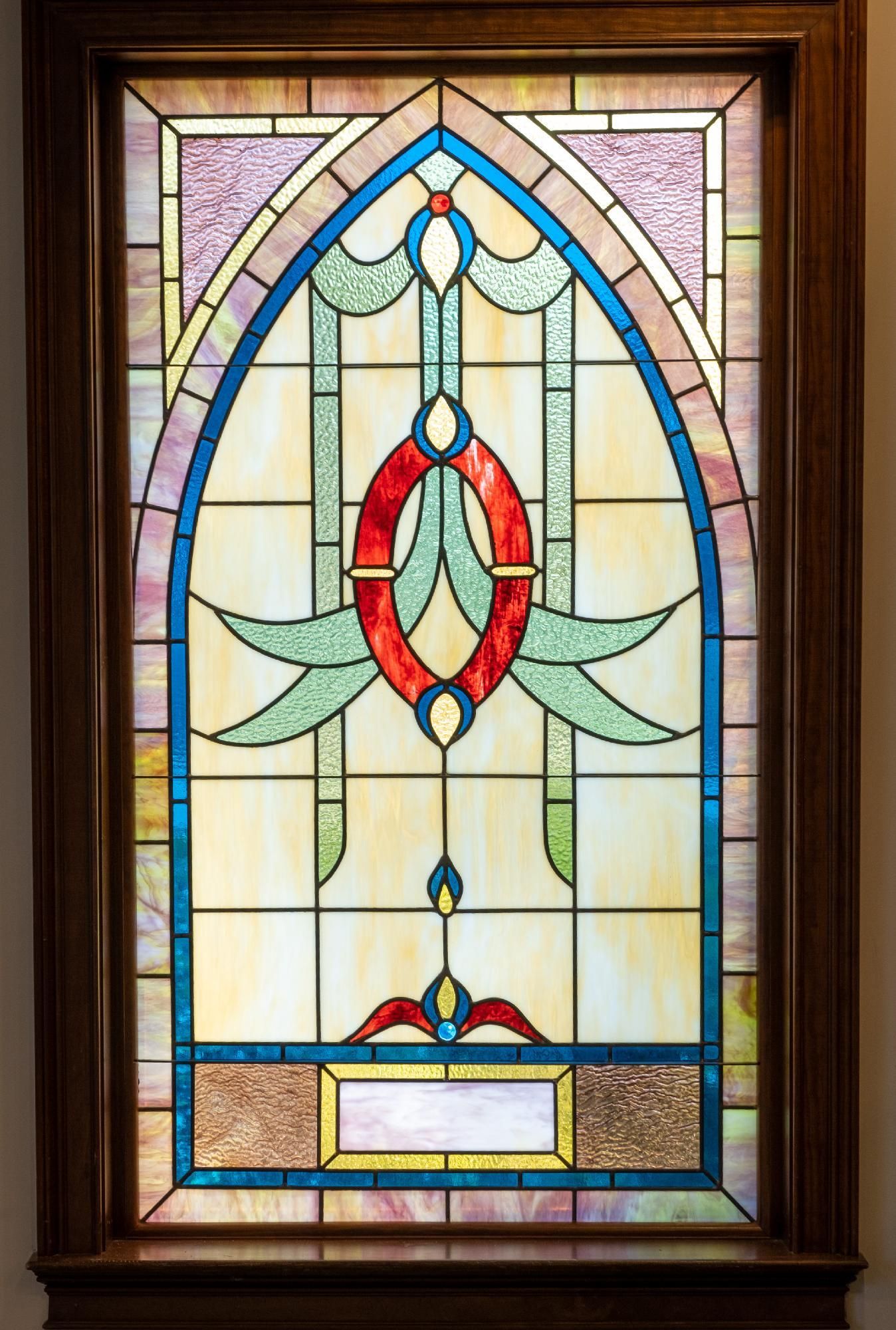 A stained glass window in a wooden frame