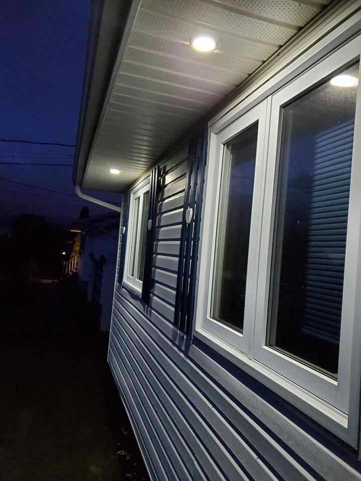 A house with a lot of windows is lit up at night.