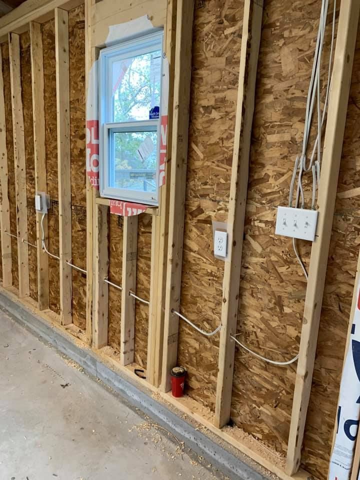 A wooden wall with a window and electrical wires.