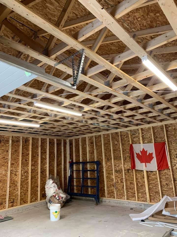 A garage under construction with a canadian flag on the wall.