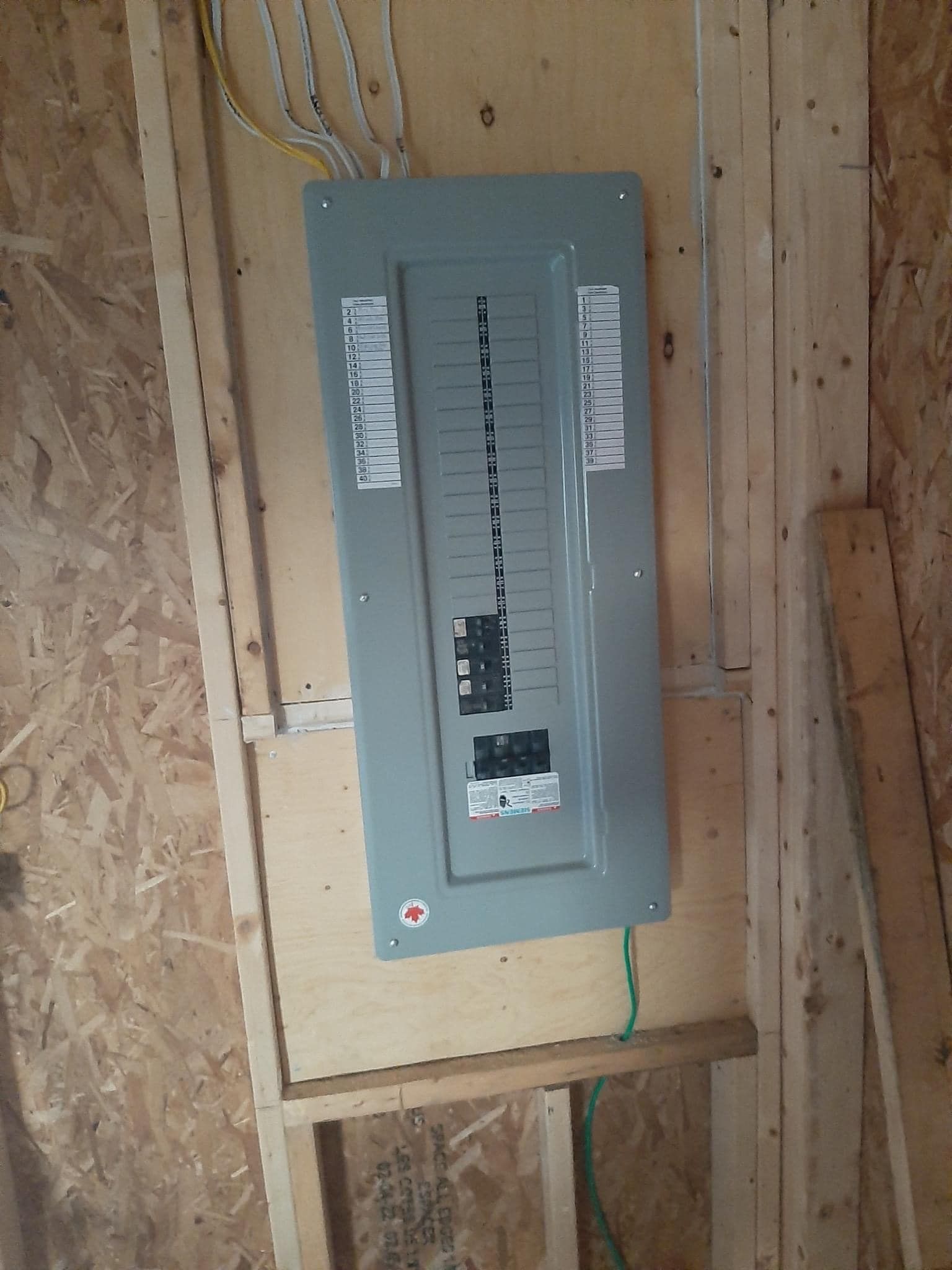 A electrical box is sitting on top of a wooden wall.