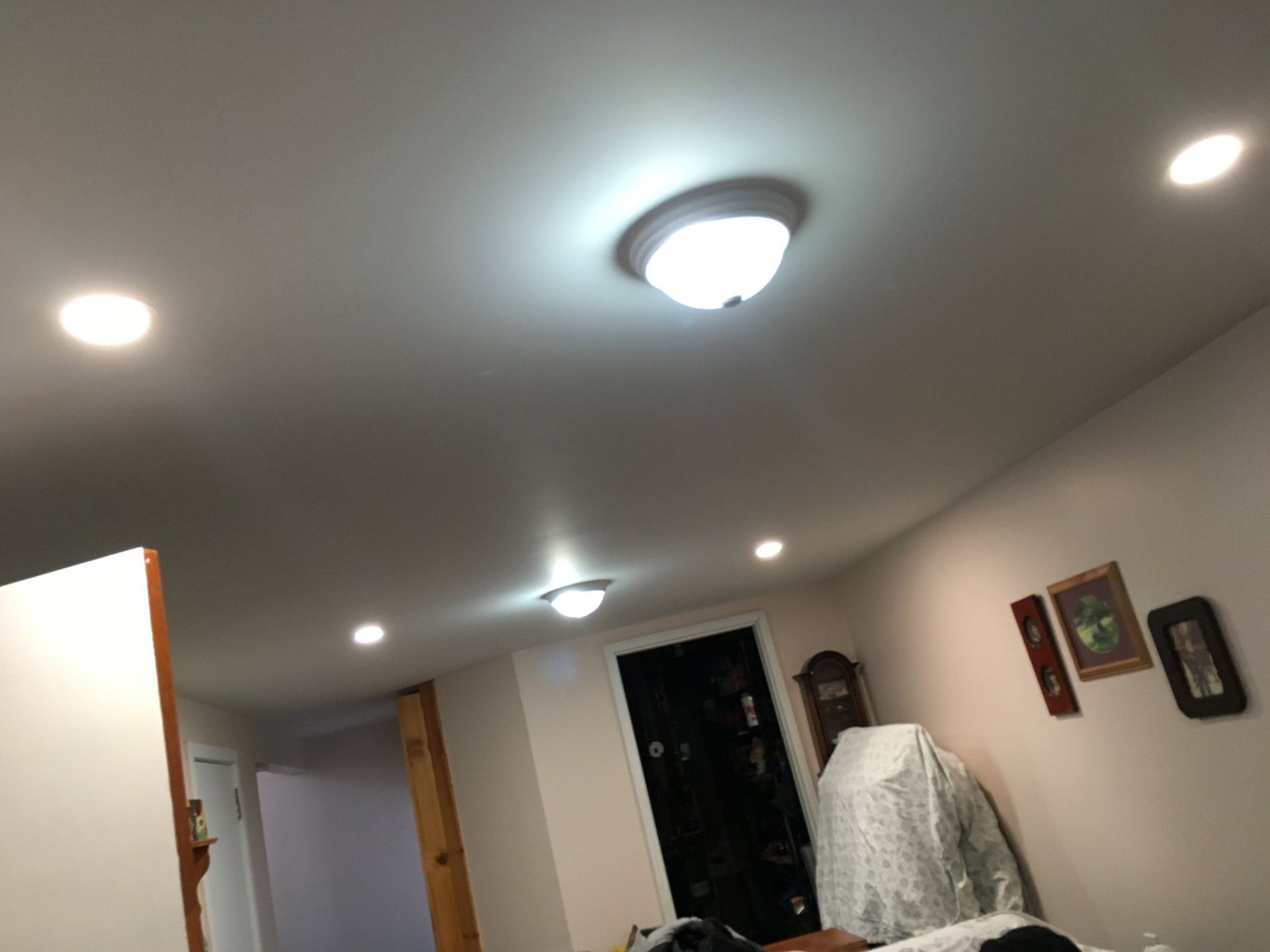 A bedroom with a ceiling light and a clock on the wall.