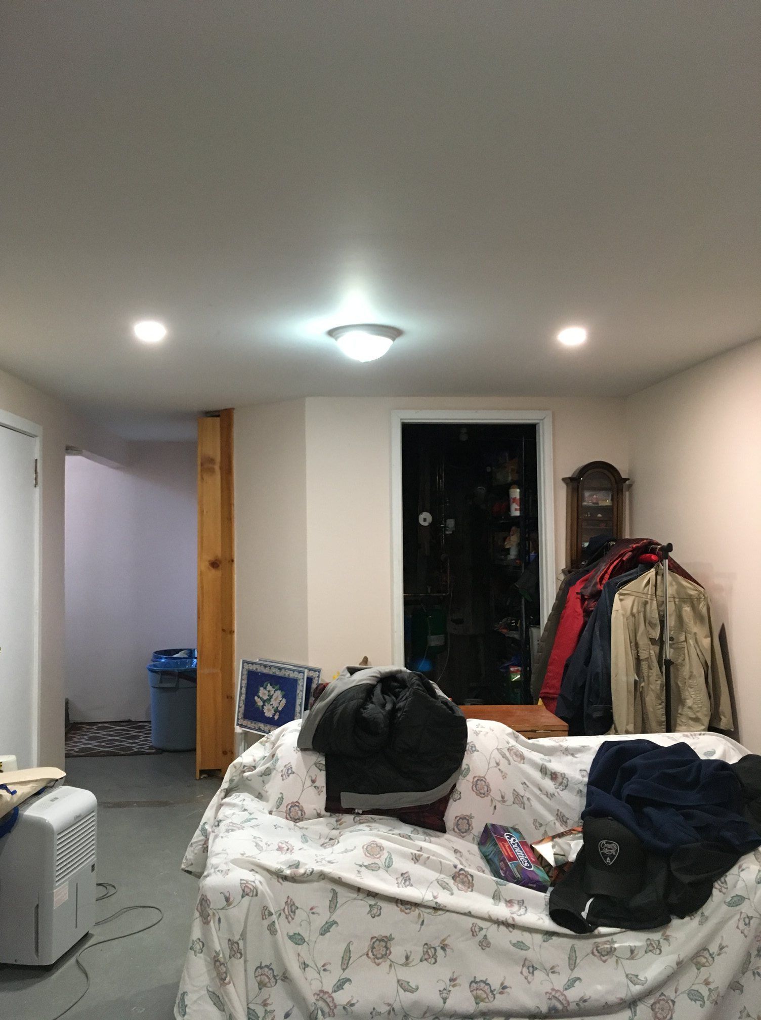 A living room with a couch and a clock on the wall.